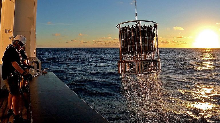 In the evening sun, a CTD with water samples is brought aboard.