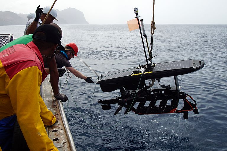 Dr. Björn Fiedler (mit rotem Helm) setzt den Wave Glider, ein nur durch Wellen- und Sonnenenergie angetriebenes Mini-Forschungsschiff, für einen längeren Einsatz bei den Kapverdischen Inseln aus. Foto: Ailton Rocha, INDP