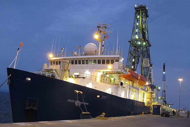 The scientific drilling vessel JOIDES RESOLUTION moored at a pier. 