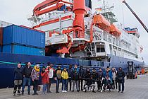 Group of scientists in front of research vessel Polarstern.