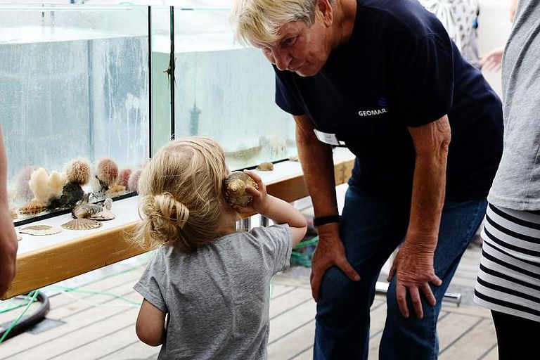 Heidi Gonschior und kleines Mädchen entdecken ein Schneckengehäuse mit allen Sinnen. Foto: Jan Steffen