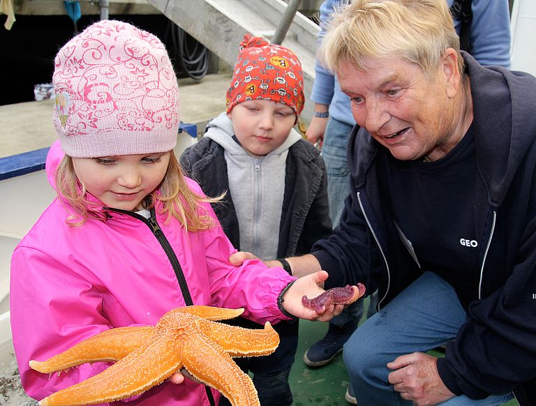 Ob der Seestern wohl piekt? Heidi Gonschior (links) zeigt den Nachwuchsforschern Meeresbewohner der Ostsee. Foto: A. Villwock, GEOMAR.