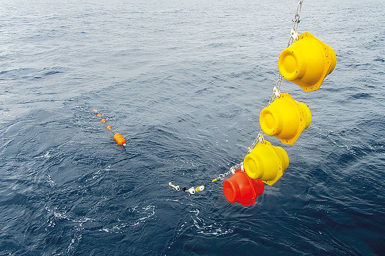 Wie eine lange Perlenkette schwimmt die Verankerung hinter dem Forschungsschiff, bevor das Ankergewicht sie Richtung Meeresboden zieht. Foto: J. Hahn, GEOMAR