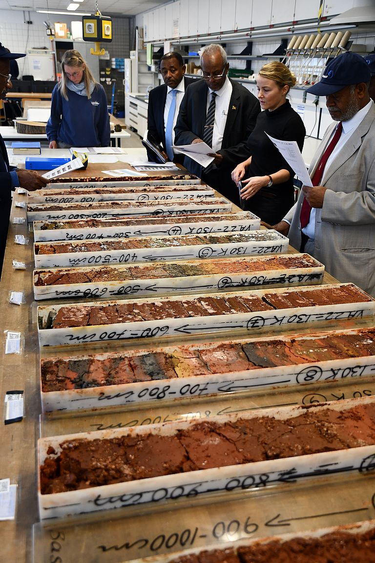 Dr. Anna Krätschell (GEOMAR, rechts) und Dr. Doris Maicher (hinten) zeigen den Gästen Sedimentkerne aus dem Roten Meer. Foto: Warner Brückmann/GEOMAR.
