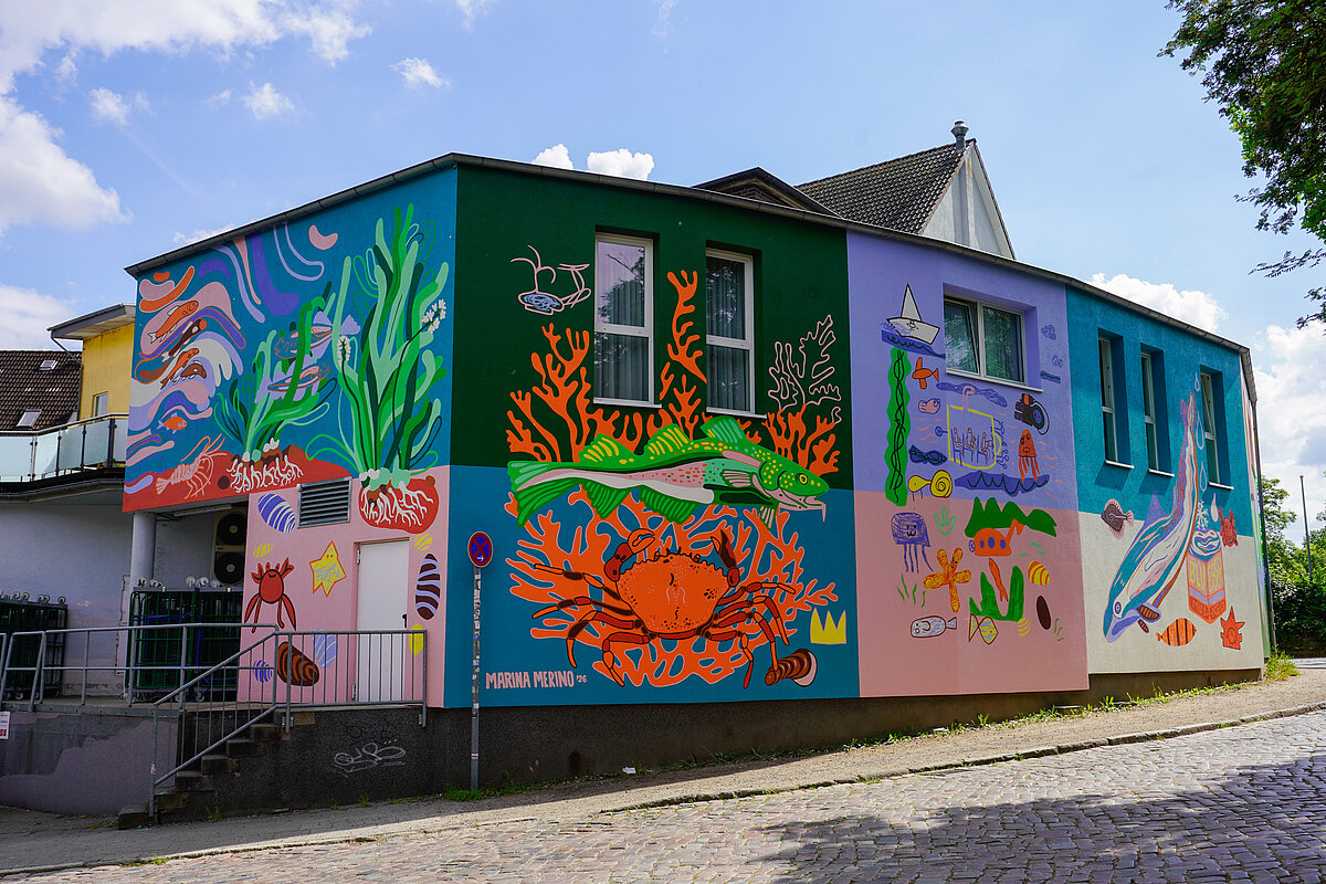 Die schlichte weiße Fassade hat sich in ein großes buntes Gemälde verwandelt, auf dem sich allerlei Tiere und Pflanzen der Ostsee tummeln. Foto: Janne Lene Polei, GEOMAR