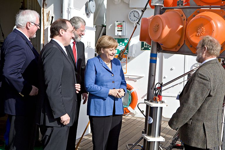 Bundeskanzlerin Angela Merkel zusammen mit Schleswig-Holsteins Ministerpräsident Peter Harry Carstensen (li.) und Wissenschaftsminister Jost de Jager (2.v.li) auf dem Forschungsschiff ALKOR. GEOMAR-Direktor Professor Peter Herzig (Mitte) und Dr. Olaf Pfannkuche präsentieren ein autonomes Tiefseelabor. Foto: F. Dott