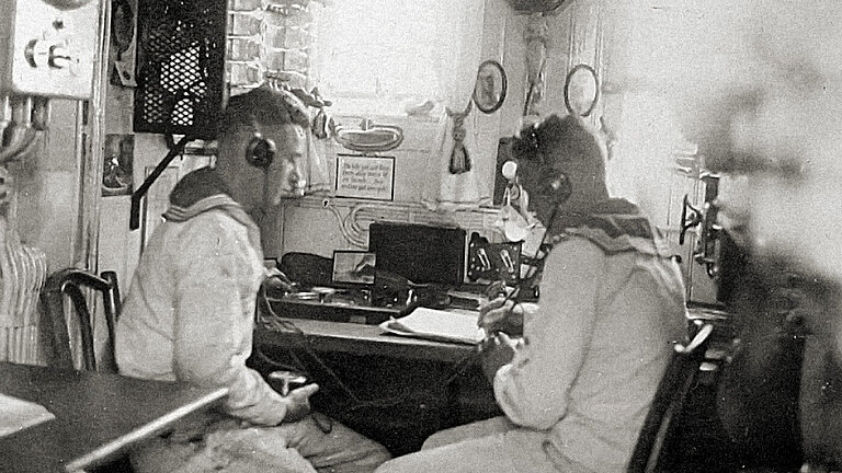 Original black-and-white photograph. Two people operating the echo sounder.