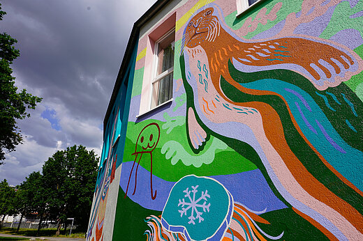 Eine große Robbe, mit bunten Farben an eine Häuserwand gemalt