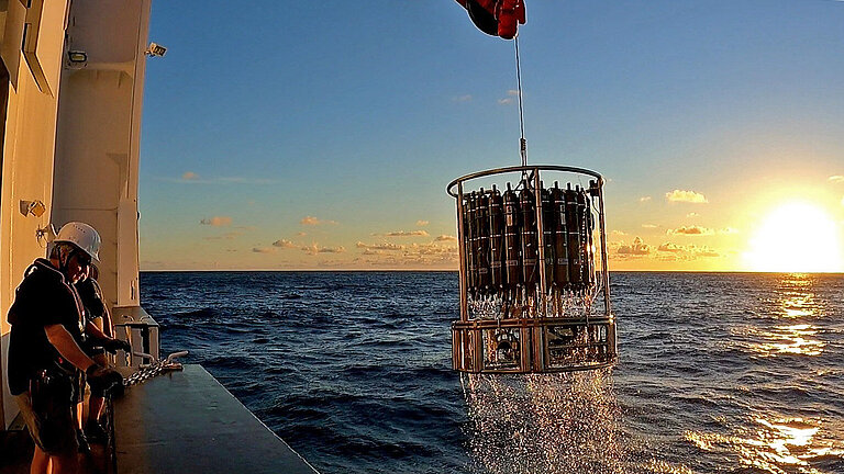 A view over the railing of a research vessel towards a research instrument (CTD-rosette)