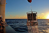 A view over the railing of a research vessel towards a research instrument (CTD-rosette)