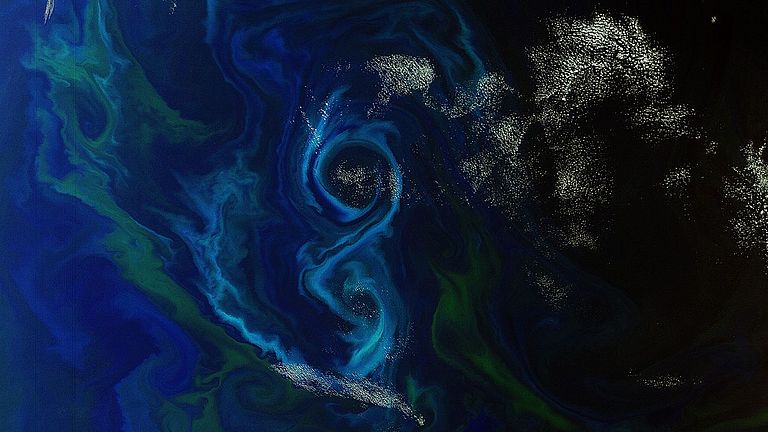 Blueish and greenish swirls on the sea as seen from spacerbel auf der Meeresoberfläche, vom All aus gesehen.