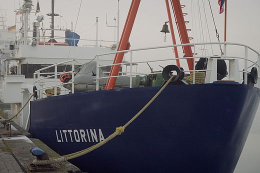 A ship is moored at the pier in the morning fog. 