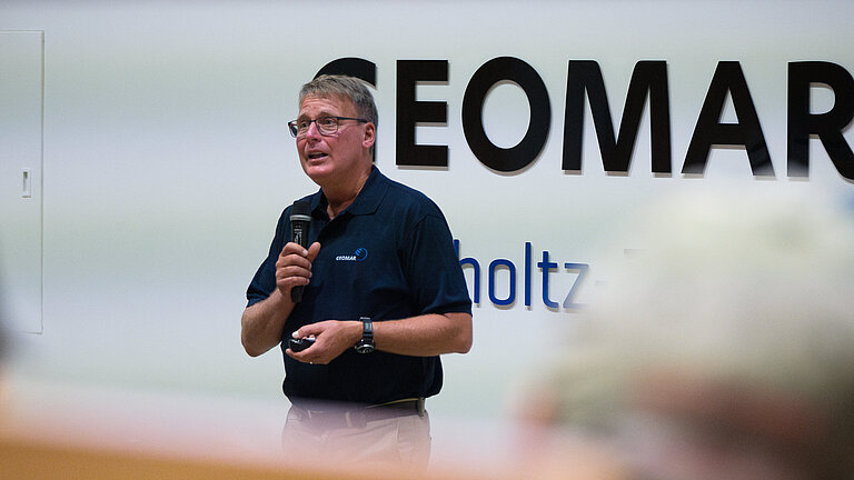 A man is giving a lecture in the lecture theatre