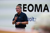 A man is giving a lecture in the lecture theatre