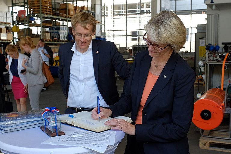 Bundesministerin Anja Karliczek und Ministerpräsident Daniel Günther tragen sich ins Gästebuch des GEOMAR ein. Foto: Jan Steffen/GEOMAR