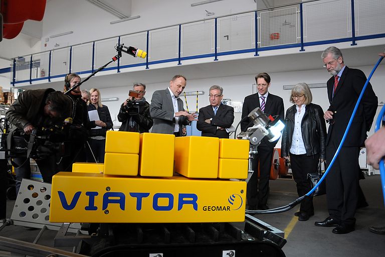 Im Technik- und Logistikzentrum informierte Leiter Dr. Peter Linke, 5.v.l. EU-Kommissar Vella über aktuelle Meerestechnik. Foto: Jan Steffen, GEOMAR.