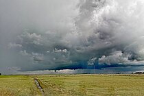 Ein Sturm zieht von der Nordsee her auf. Dicke Wolken türmen sich über grünem Grasland.