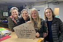 Four researchers stand at a table and present the memorial stone for Professor Dr Erwin Suess.