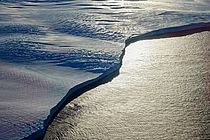 Ein Eisrand am Meer im Sonnenschein