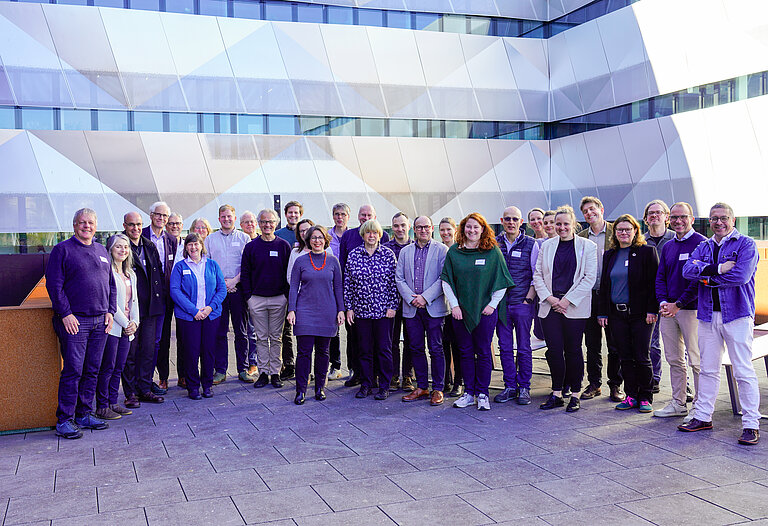 A large group of people are standing on the roof terrace