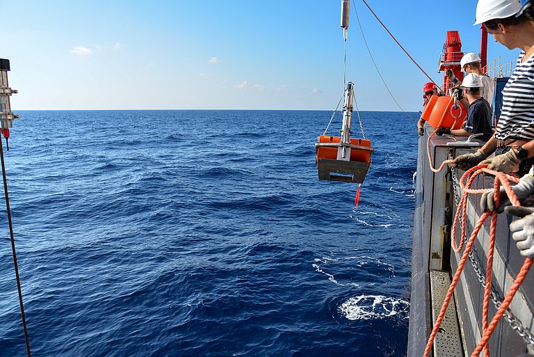 Ein GeoSEA-Transponder mit Ankergewicht und orangenen Auftriebskörpern hängt neben der Bordwand der FS SONNE.
