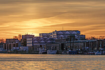 Gebäude an einem Fluss in goldenem Morgenlicht