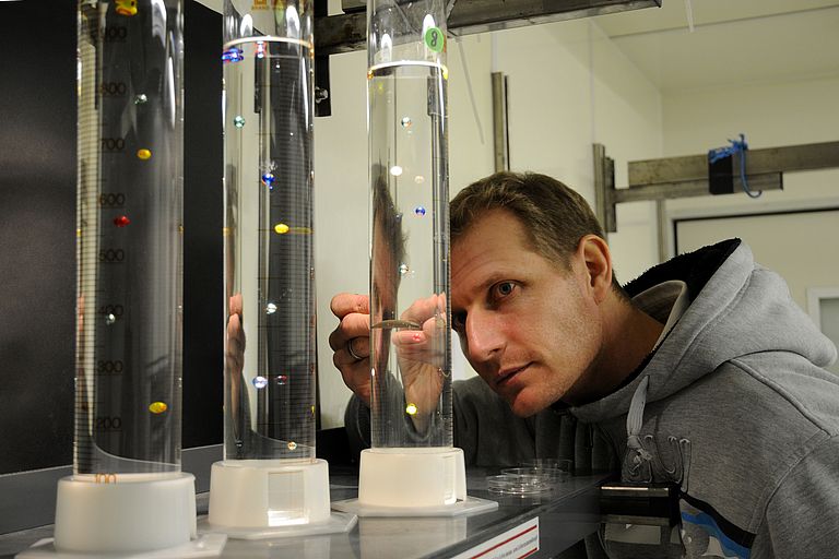   Glass cylinders with precisely calibrated salt water stratification are used to determine the density of fish eggs. Photo credit: Maike Nicolai, GEOMAR
