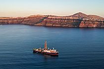 Ein Schiff in der Abendsonne vor einer Küste