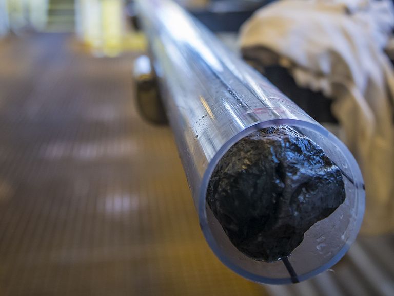 The picture shows a long tube containing a drill core.