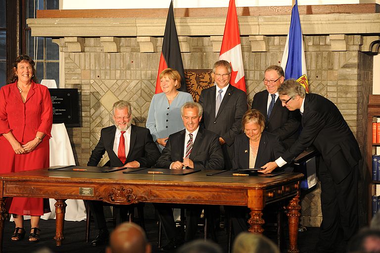 In Anwesenheit von Bundeskanzlerin Angela Merkel, des kanadischen Ministers für Wissenschaft und Technologie Gary Goodyear sowie des Premierministers der Provinz Nova Scotia Darrel Dexter (stehend hinten) unterzeichnen GEOMAR-Direktor Professor Dr. Peter Herzig, der Vize-Präsident der Helmholtz-Gemeinschaft Professor Dr. Reinhard Hüttl und die Vize-Präsidentin der Dalhousie-Universität Professor Dr. Martha Crago (sitzend v.l.n.r.) das kanadisch-deutsche Kooperationsabkommen. Foto: Dalhousie-University