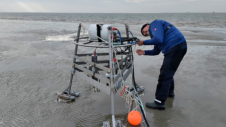 A picture of a metal frame with sensors attached to it, and a man adjusting something on them