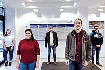 Three men and two women stand with distances in the foyer of GEOMAR at Düsternbrooker Weg