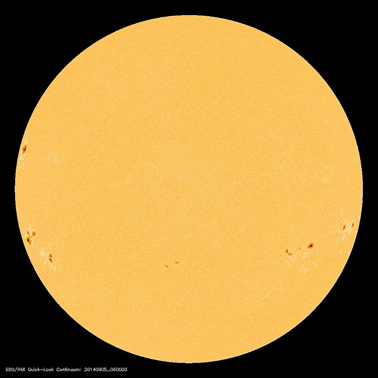 Abgebildet sind Sonnenflecken zur Zeit eines Sonnenfleckenminimums. Magnetfelder treten aus bestimmten Regionen der Sonnenoberfläche aus und vermindern dadurch lokal die Leuchtkraft der Sonnenstrahlen. Sonnenflecken werden somit im Vergleich zur restlichen Sonnenoberfläche als dunkle Flecken wahrgenommen. Foto: SOHO (ESA & NASA)