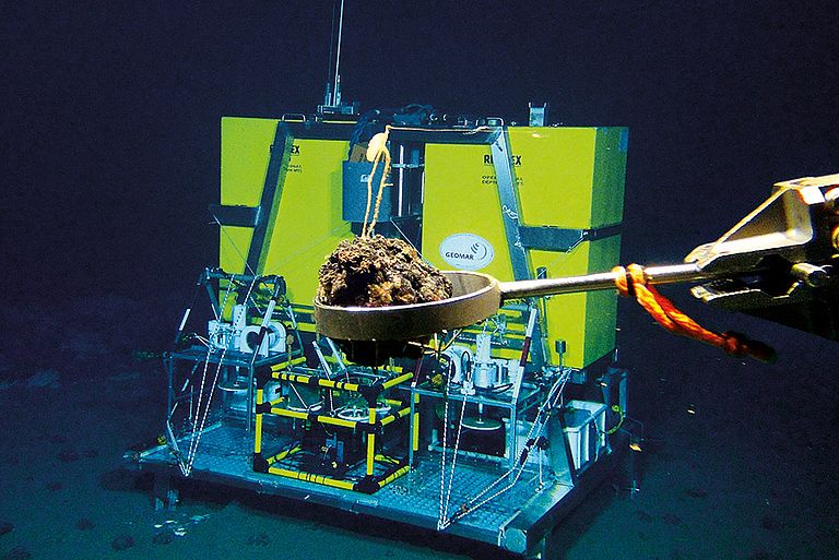 Ein Fahrstuhl-Lander. Mit diesem Gerät können mehrere Experimente gleichzeitig am Meeresboden abgesetzt werden. Im Vordergrund: Manganknolle im Greifarm des ROV KIEL 6000. Foto: ROV-Team, GEOMAR