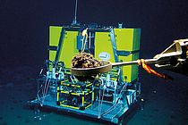Ein Fahrstuhl-Lander. Mit diesem Gerät können mehrere Experimente gleichzeitig am Meeresboden abgesetzt werden. Im Vordergrund: Manganknolle im Greifarm des ROV KIEL 6000. Foto: ROV-Team, GEOMAR