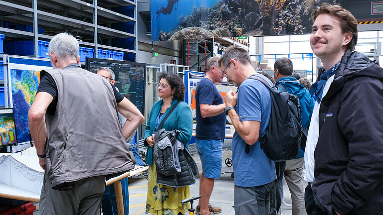 A group of visitors in a hall with information stands