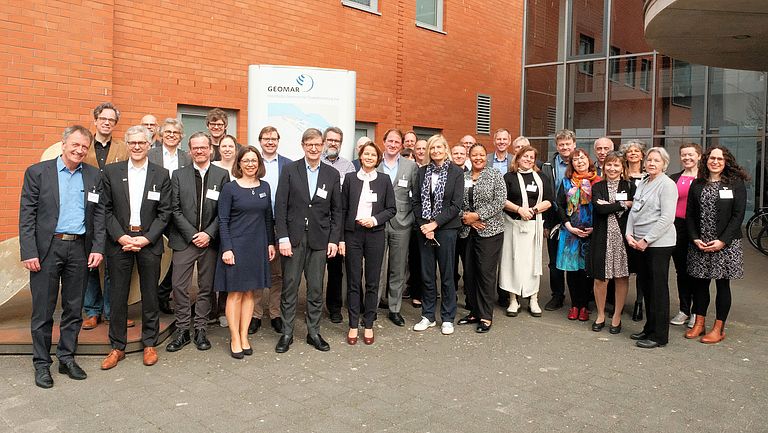 Eine Gruppe Menschen steht vor einem Gebäude