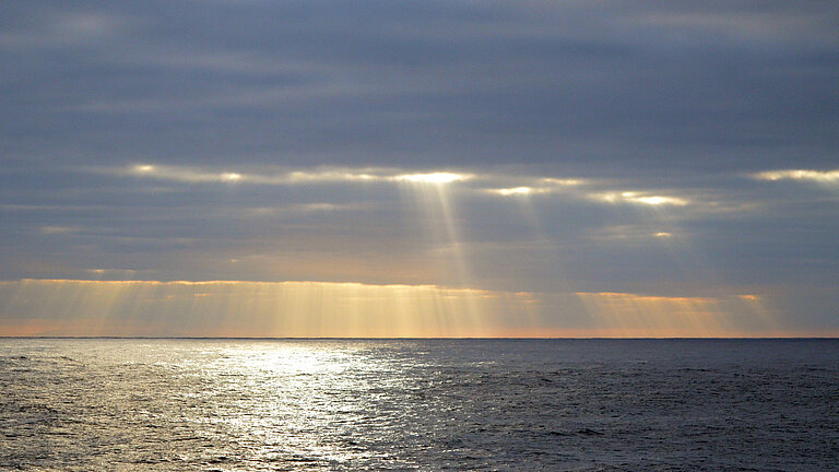 Sonne bricht durch die Wolkendecke über dem Horizont des Pazifiks