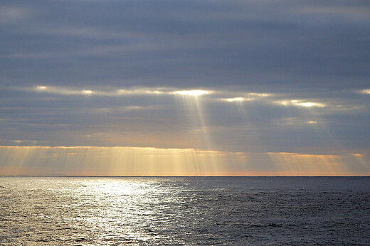 Sonne bricht durch die Wolkendecke über dem Horizont des Pazifiks