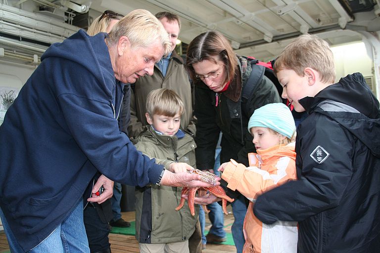 Ob der Seestern wohl piekt? Heidi Gonschior (links) zeigt den Nachwuchsforschern Meeresbewohner der Ostsee. Foto: A. Villwock, GEOMAR.