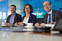 Drei Personen an einem Tisch