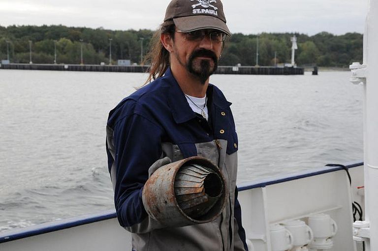 Techniker Asmus Petersen hält die "Apfelsine", die verhindert, dass der Bohrkern wieder aus dem Rohr herausrutscht. Foto: Jan Steffen, GEOMAR.