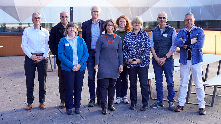 A group of people on a roof terrace, four women and five men
