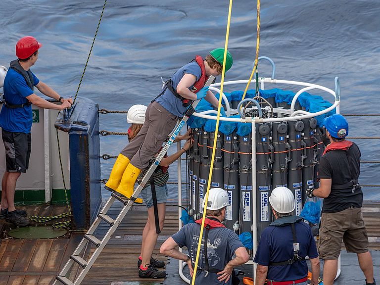 Researchers on board a ship set up the trace metal clean rosette water sampler.