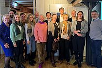 Eine Gruppe Menschen lächelt in die Kamera