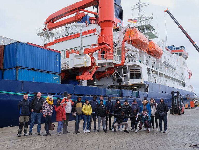 Group of scientists in front of research vessel Polarstern.