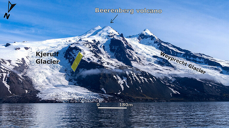 Bild von schneebedeckten Bergen direkt am Meer, an zwei Stellen reicht das Eis bis zur Küste, das sind die beiden Gletscher.