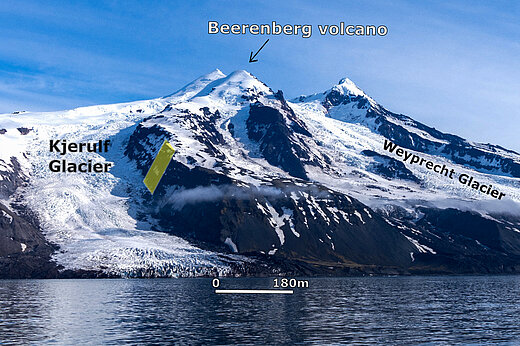 Bild von schneebedeckten Bergen direkt am Meer, an zwei Stellen reicht das Eis bis zur Küste, das sind die beiden Gletscher.