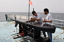 Letzter Check vor dem Einsatz: Patrick Leibold und Warith Al Sheibany kontrollieren den Wave Glider an Bord der AL SEERAH. Foto: Warner Brückmann/GEOMAR