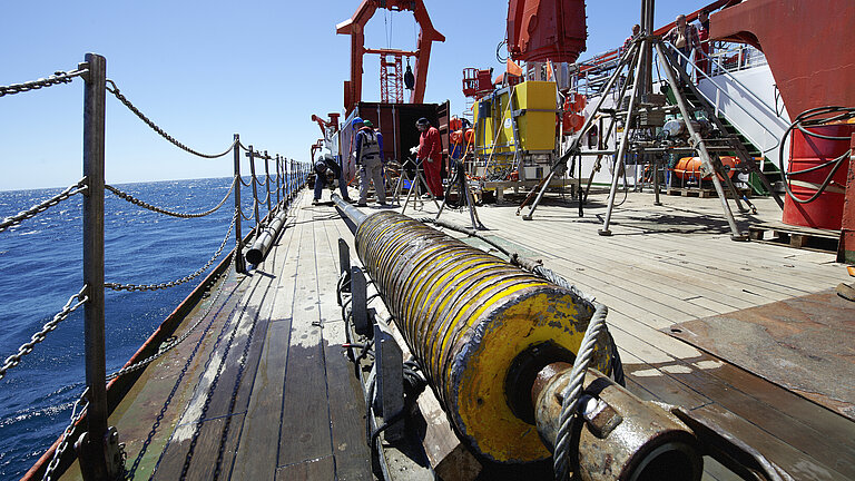 A gravity meter on the working deck of a research vessel. In the background, the water and the sky.